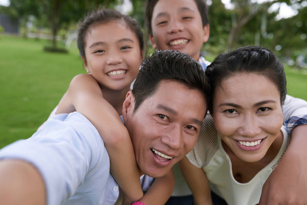 οικογένεια που αγκαλιάζει κατά τη λήψη selfie - Φωτογραφία, εικόνα