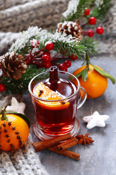 Traditional winter beverage mulled wine. Christmas drink. Gray background with knitted scarf - 写真・画像