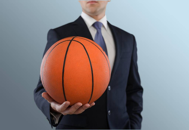 Businessman in suit holding basketball ball - Foto, Imagen