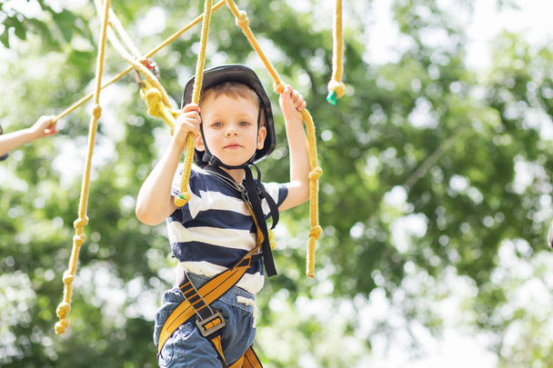 Děti v parku dobrodružství. Chlapec stojí horolezecké lano - Fotografie, Obrázek