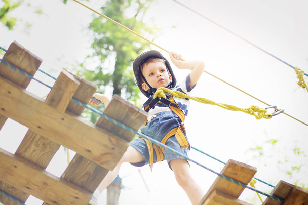 Děti v parku dobrodružství. Chlapec stojí horolezecké lano - Fotografie, Obrázek