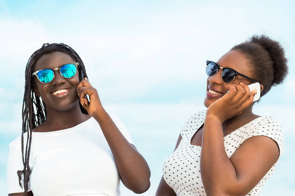 Δύο διαφορετικές αφρικανική έφηβοι μιλούν για smart phones. - Φωτογραφία, εικόνα