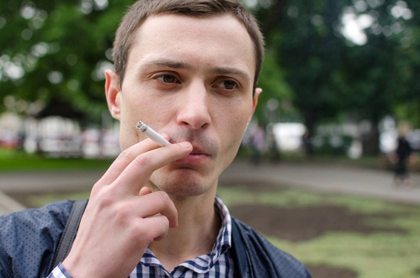 Young man smoking cigarette - Foto, Imagen