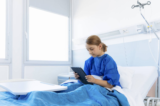 Lány beteg, kórházban a tábla-pc használata - Fotó, kép