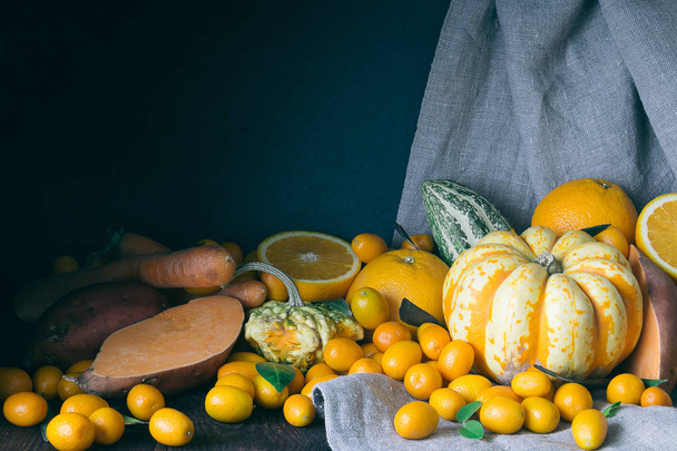 Pumpkins, Kumquats, Orange, Sweet Potato, Carrot, Autumn Composition on Dark Wooden Background, Toned Picture, Free Space for Text - Foto, afbeelding