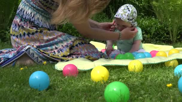Материнские руки надели шапочку на несчастную голову маленькой дочери в открытом парке. 4K
 - Кадры, видео