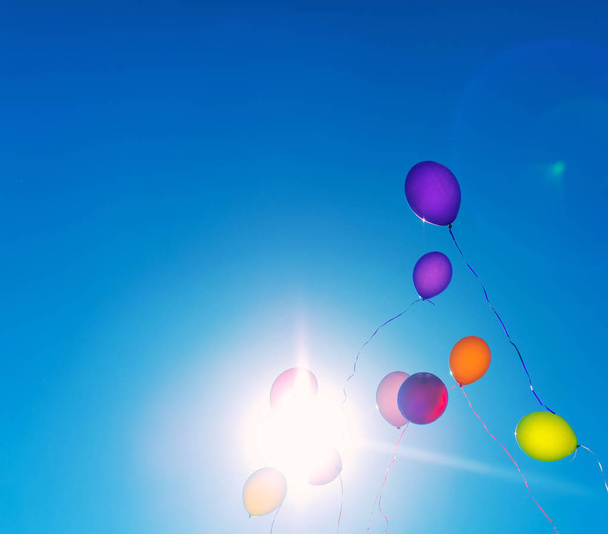 Muchos globos de colores en el cielo azul. Lugar para su texto
. - Foto, imagen