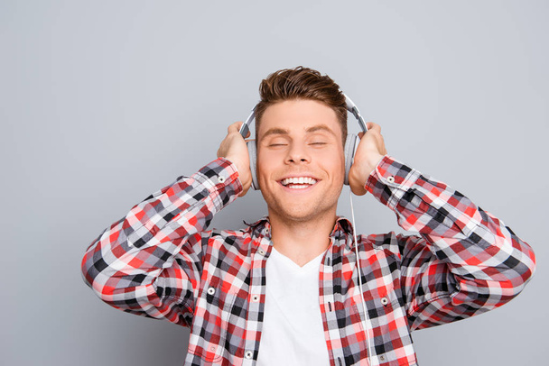 Portrait of happy music lover listening music in headphones - Photo, Image