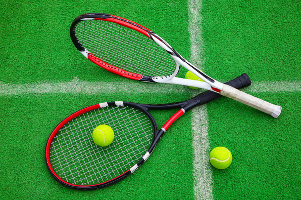 tennis racket with balls on green grass - 写真・画像