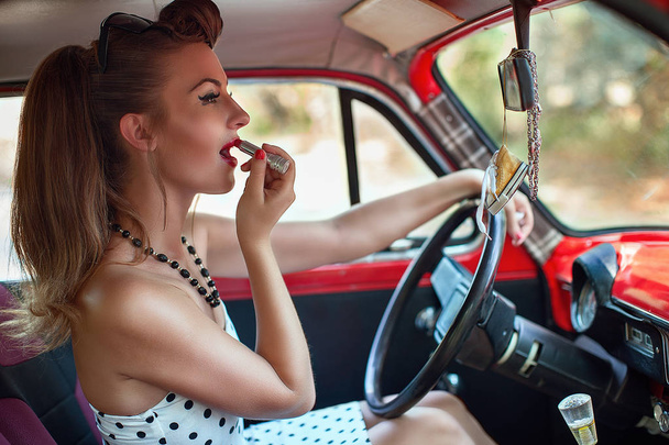 girl putting on lipstick while driving - Foto, Imagen