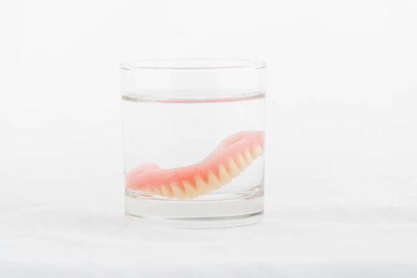 Dentaduras em vidro de água
 - Foto, Imagem