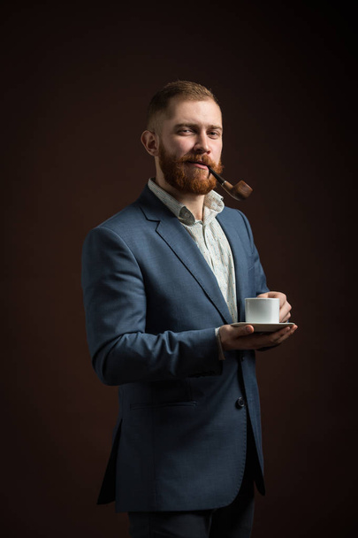 Portrait of man in suit smoking pipe - 写真・画像