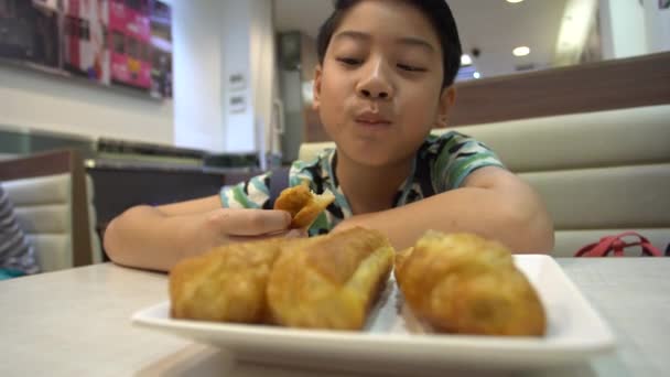 Счастливый мальчик азиатских подростков наслаждаться едой в завтрак
. - Кадры, видео