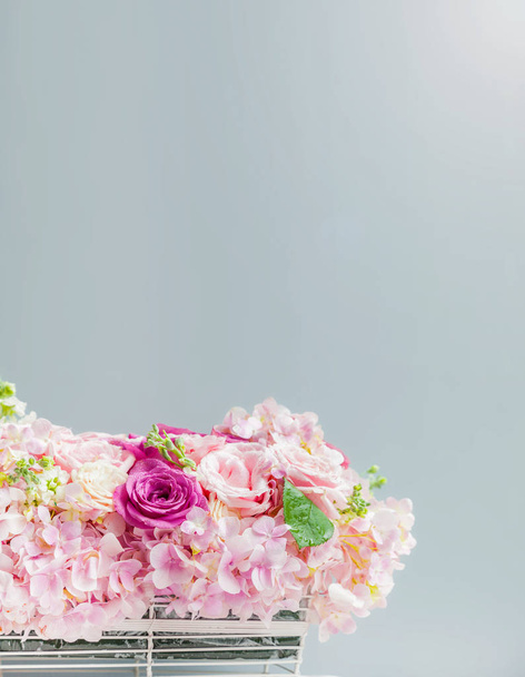 цветочная корзина на скатерти перед серой стеной
 - Фото, изображение