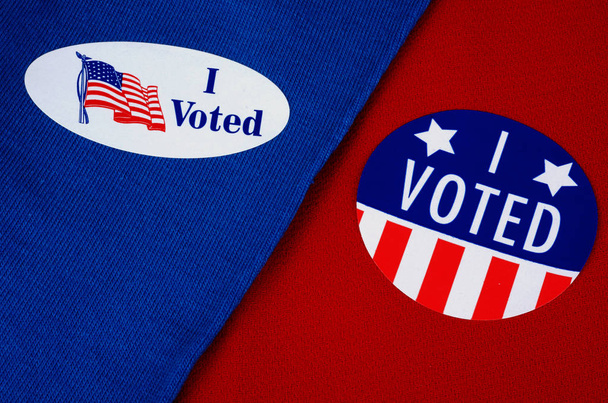 "Voté "Etiqueta de votante dada en las elecciones, sobre fondo rojo y azul
 - Foto, Imagen