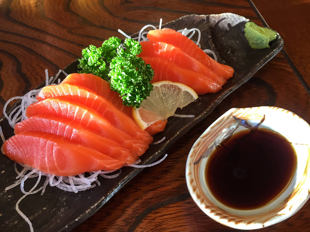 Somon çiğ sashimi ahşap masa üzerinde. Kapandı. - Fotoğraf, Görsel