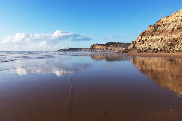 Hegyi tükröződik a sima víz a strand Areia Branca. Lourinha, Portugália - Fotó, kép
