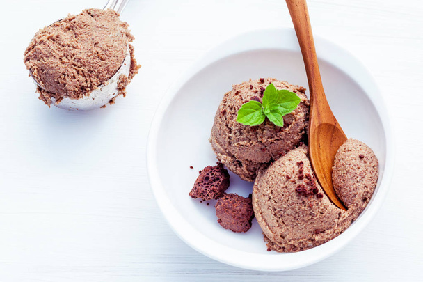 Cerrar helado de chocolate en un tazón blanco con menta fresca
 - Foto, imagen
