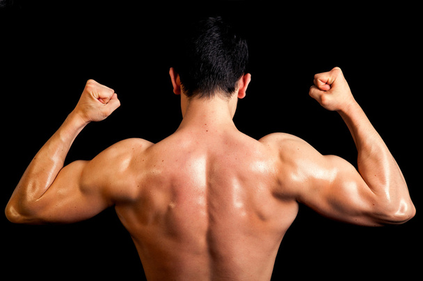 Muscular back of healthy male on black background. - Photo, Image