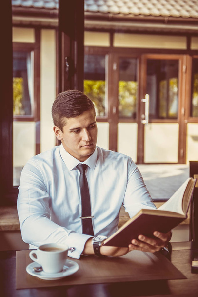 young businessman reading a book in cafe - Foto, afbeelding