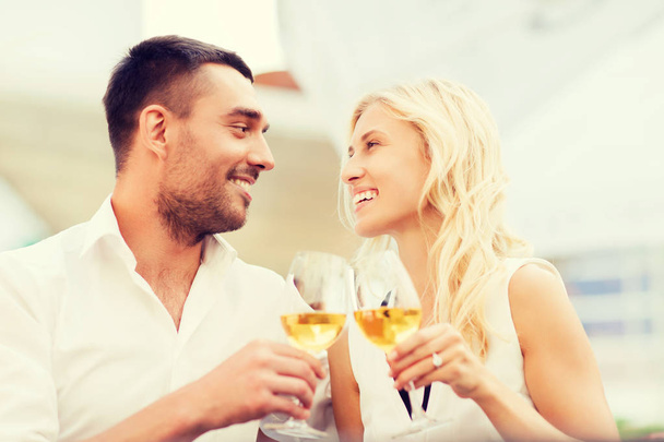 happy couple clinking glasses at restaurant lounge - Fotó, kép