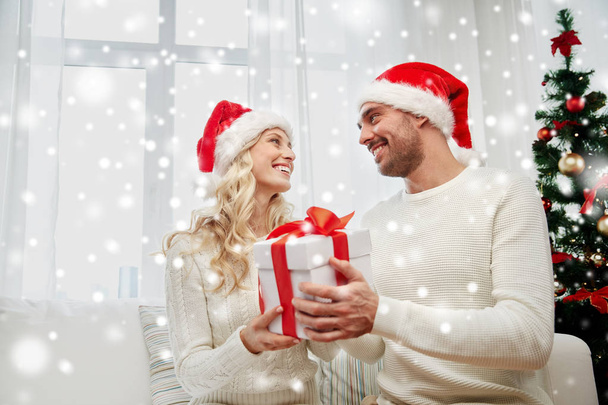 happy couple at home with christmas gift box - 写真・画像
