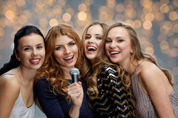 happy young women with microphone singing karaoke - Zdjęcie, obraz
