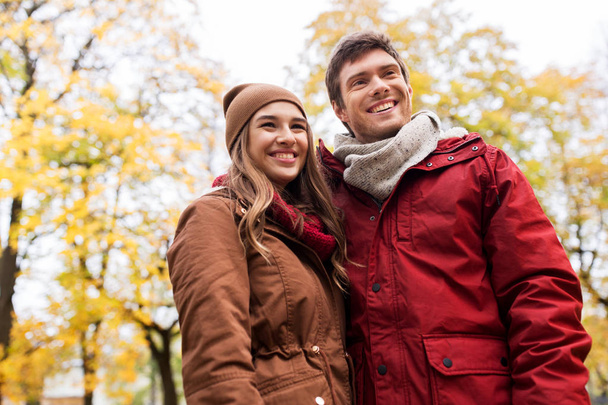 秋の公園で歩く幸せな若いカップル - 写真・画像