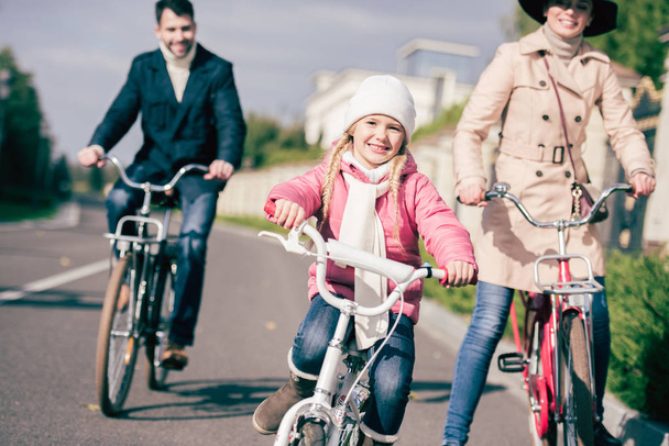 Cheerful family biking in park  - Фото, зображення