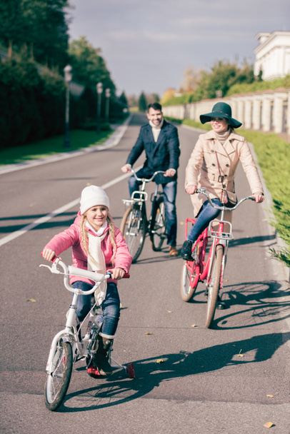 Cheerful family biking in park  - 写真・画像
