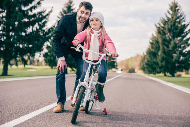 Padre enseñando a su hija a montar en bicicleta - Foto, Imagen