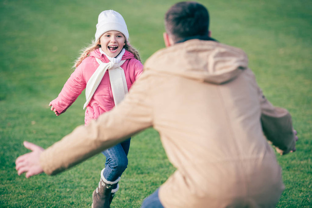 Adorable chica sonriente corriendo a padre
  - Foto, imagen