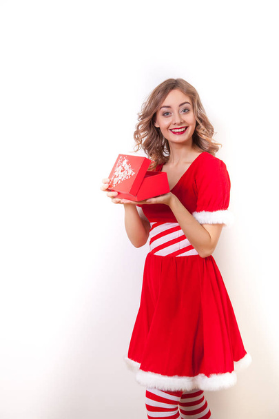 Beautiful Happy girl in Santa Claus clothes opens a gift - Foto, immagini