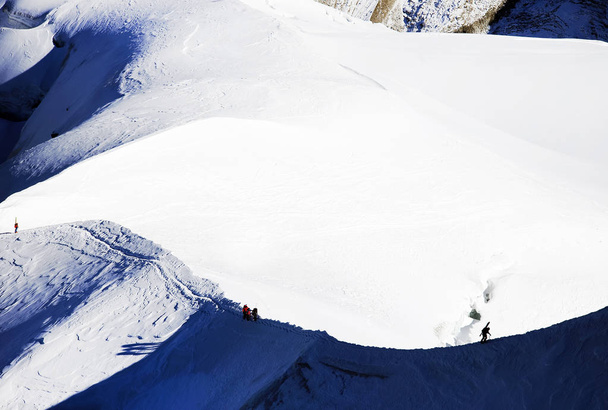 秋のエギーユ ・ デュ ・ ミディ山に登るアルピニスト - 写真・画像
