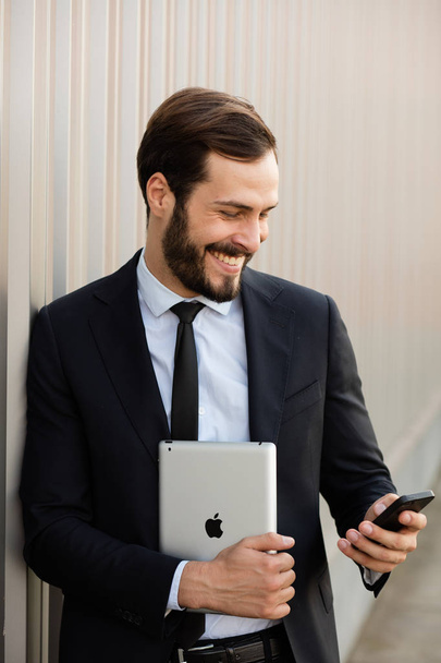 smiling man with tablet and cellphone outside - Photo, Image