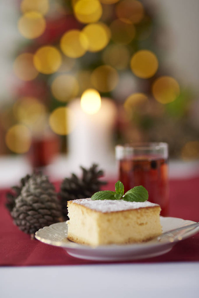 チーズケーキとバック グラウンドでクリスマス ツリー - 写真・画像