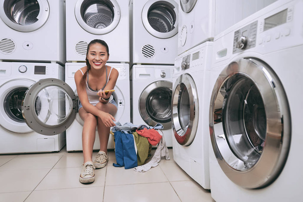 γυναίκα που κάθεται στο πλυντήριο ρούχων - Φωτογραφία, εικόνα
