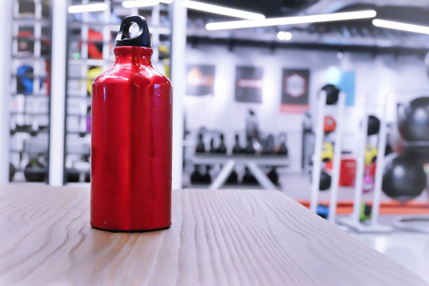 πετσέτα και ένα μπουκάλι κόκκινο νερό στο άθλημα σύλλογο ή γυμναστήριο και fitness r - Φωτογραφία, εικόνα