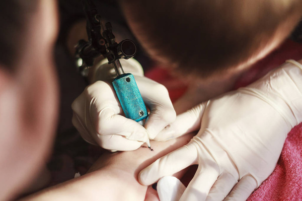 tatuador tem uma tentativa de braço menina
 - Foto, Imagem