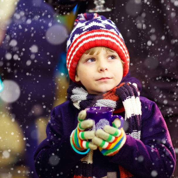 Kleiner Junge mit heißer Schokolade auf dem Weihnachtsmarkt - Foto, Bild