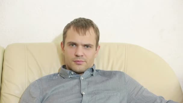 man with remote control watching tv at home - Кадры, видео