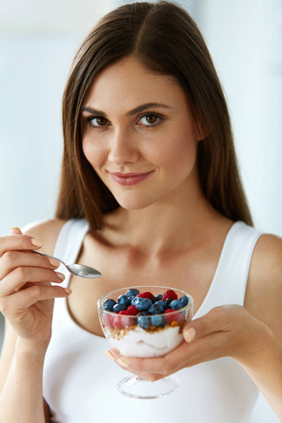 Beautiful Woman Eating Yogurt, Berries And Cereal. Healthy Diet - Foto, Imagen