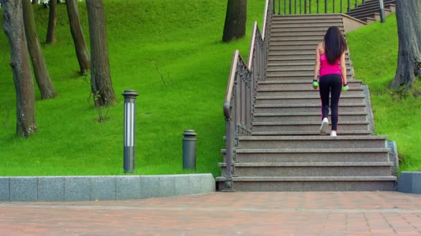 Jonge vrouw lopen trap. Sportieve meisje traplopen - Video