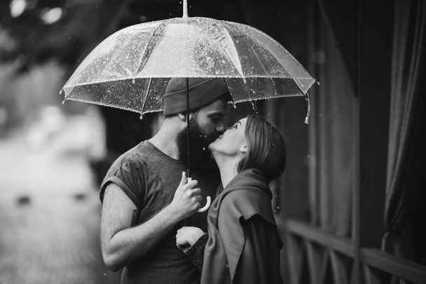 cara e a menina beijando sob um guarda-chuva
 - Foto, Imagem
