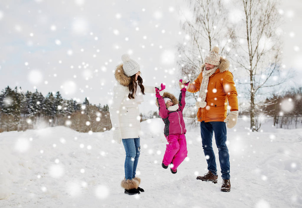 happy family in winter clothes walking outdoors - Foto, imagen