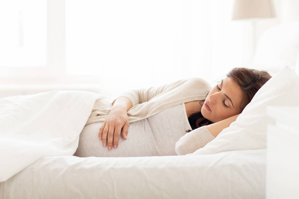 evde yatakta uyuyan mutlu hamile kadın - Fotoğraf, Görsel