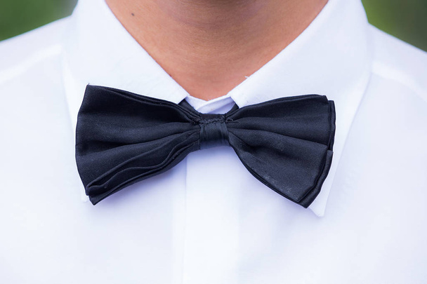 Zwarte zijden strikje en witte katoenen jurk shirt - Foto, afbeelding