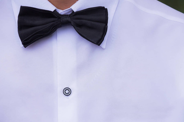 Zwarte zijden strikje en witte katoenen jurk shirt - Foto, afbeelding