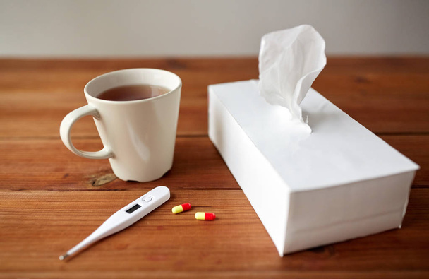 cup of tea, paper wipes and thermometer with pills - Фото, зображення