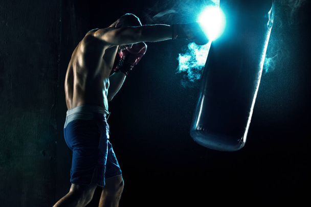 Male boxer boxing in punching bag - Foto, Imagem